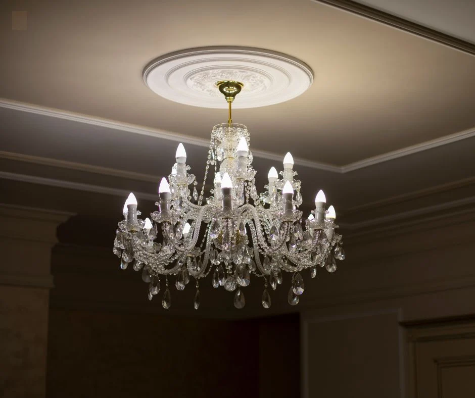 Decorative plaster ceiling rose and cornice above a chandelier