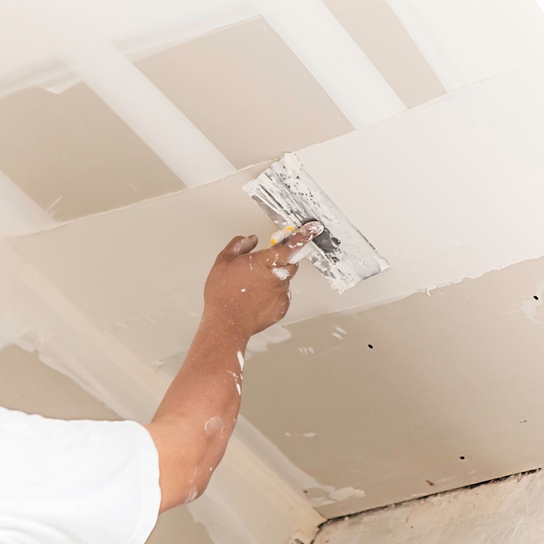 Plasterer repairing and finishing a ceiling